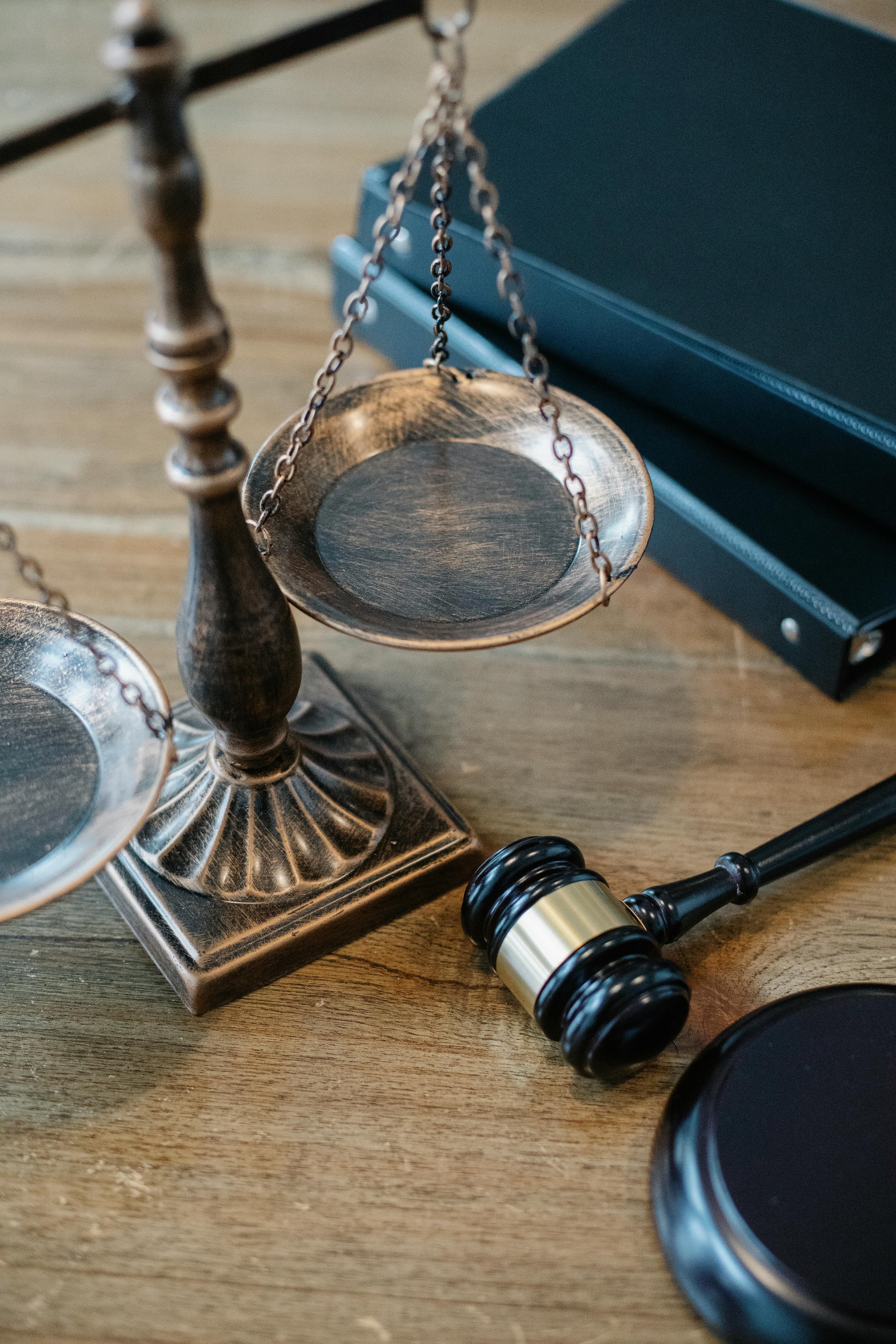 Balance de la justice et marteau judiciaire posés sur un bureau en bois